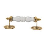 Vintage ribbed glass and brass pull handle with center on a rustic wooden drawer