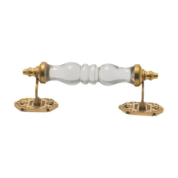Vintage ribbed glass and brass pull handle with center on a rustic wooden drawer