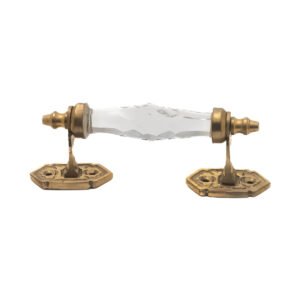 Elegant clear faceted crystal and brass pull handle with a 5-inch center on a dark wood cabinet