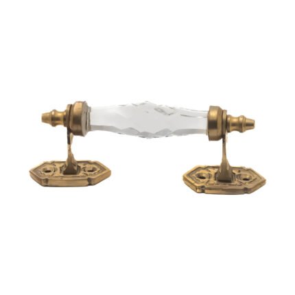 Elegant clear faceted crystal and brass pull handle with a 5-inch center on a dark wood cabinet