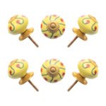 Sunny yellow hand-painted ceramic knob on a white kitchen cabinet